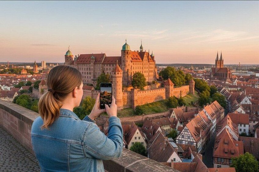A person taking a photo of a historic castle with a cityscape in the background. 3