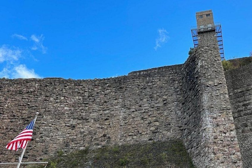 Un muro de piedra con un asta y la bandera estadounidense. 2