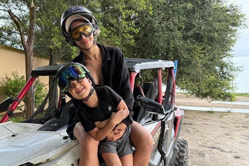 A person and a child on a dune buggy. 4