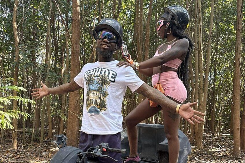 A man and a woman in a forest, both wearing helmets and casual clothing. 3