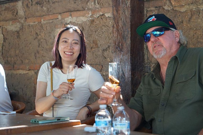 Two people sitting at a table with drinks, a smartphone, and water bottles. 2