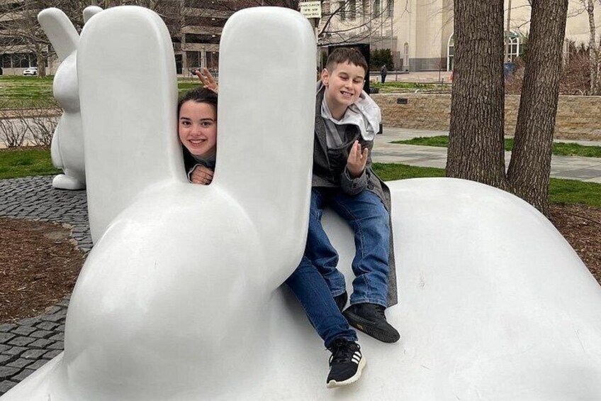 Deux personnes sont assises sur une grande sculpture blanche qui ressemble à la tête d’un lapin. 3