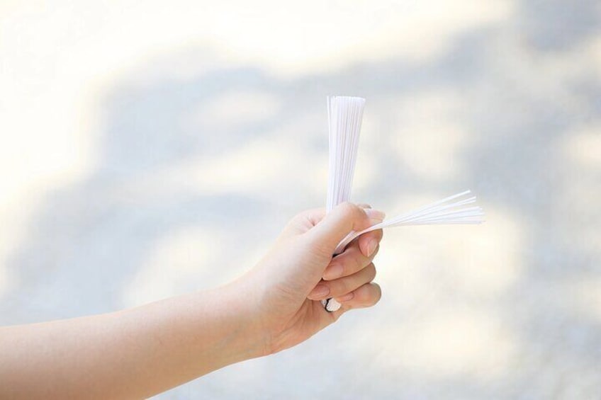 Een hand houdt een stapel witte papieren vast voor een onscherpe achtergrond. 5