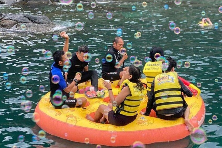 People on a yellow inflatable raft in water with bubbles. 3