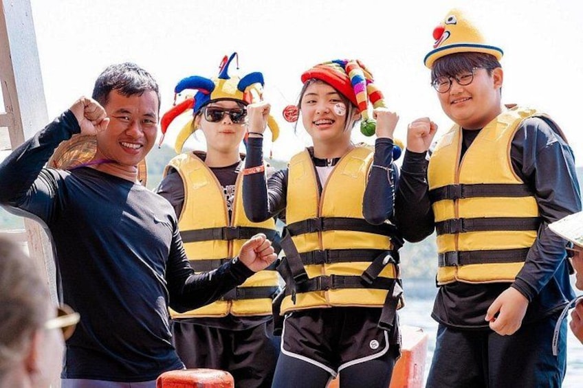 Four people wearing yellow life jackets and colorful headgear. 5