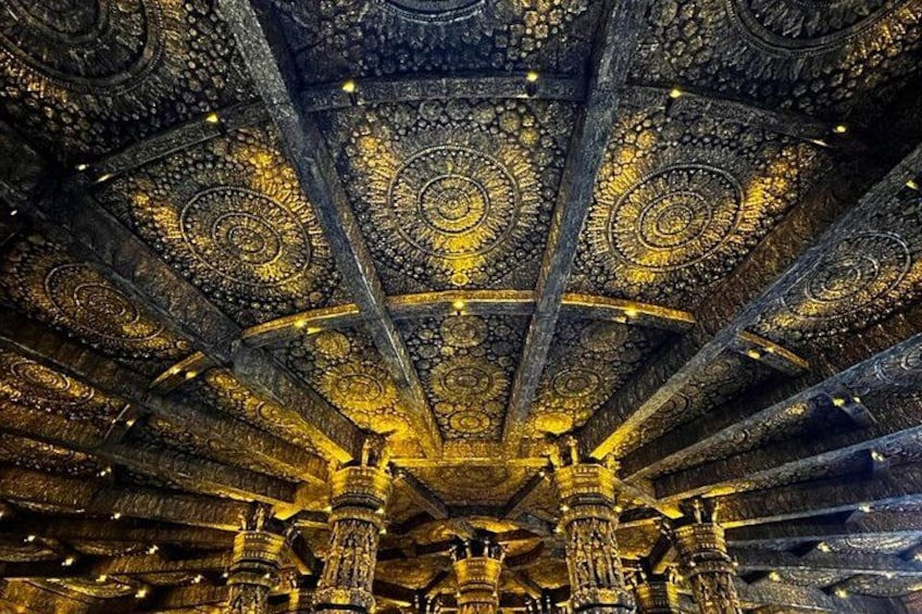 Un plafond richement décoré, orné de motifs dorés complexes et de colonnes. 1