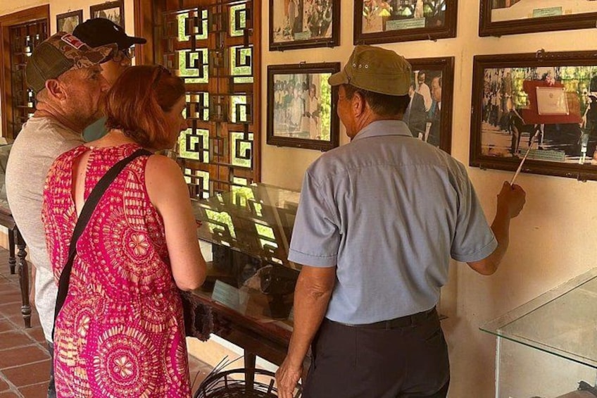A group of people examining framed photographs on a wall. 5