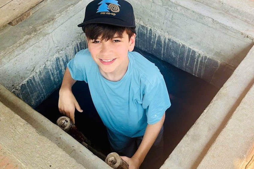 A person in a concrete pit holding a skateboard. 4