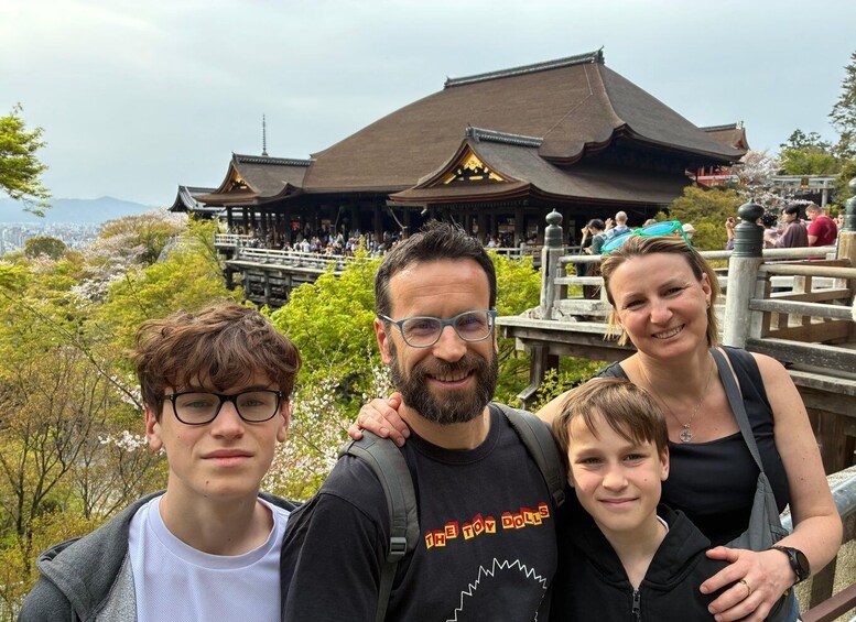 A family at a traditional Japanese temple with cherry blossoms in the background. 4