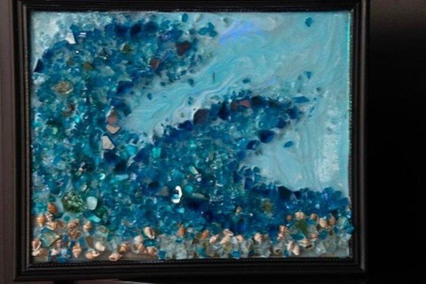 A framed abstract art piece with blue and green hues and a textured surface. 1