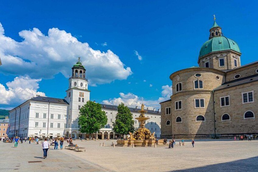 A square with a fountain, historic buildings, and a clock tower. 4