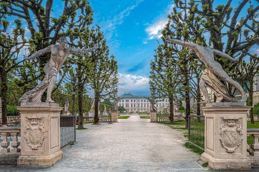 A grand entrance with statues and a building in the background. 3