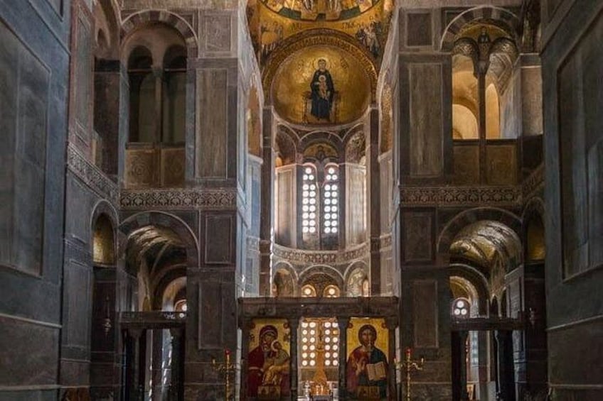 An interior of a cathedral with arched ceilings, stained glass windows, and religious iconography. 3
