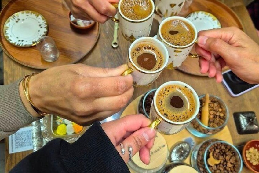 Hands holding coffee cups with a tray of food and condiments. 3