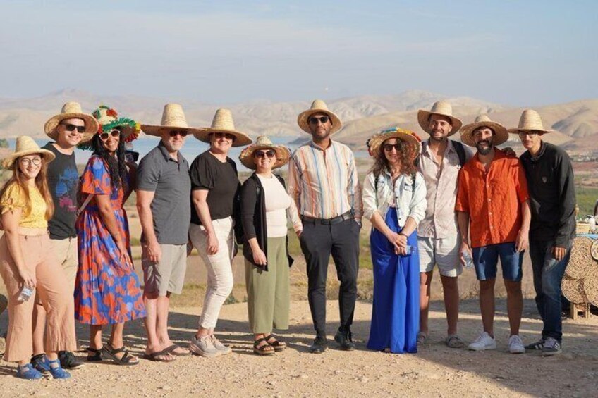 Un groupe de personnes se tient à l’extérieur, avec un paysage montagneux en arrière-plan. 1