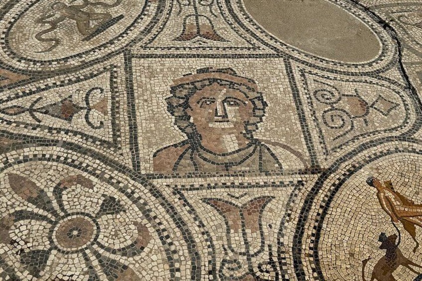 A mosaic with geometric patterns and a central figure. 2