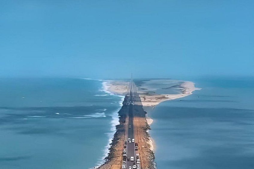 A coastal road with vehicles, a beach, and a clear sky. 3