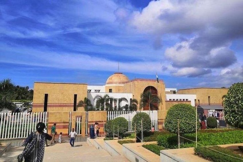 A building with a dome and arched windows, surrounded by a white fence and greenery. 4