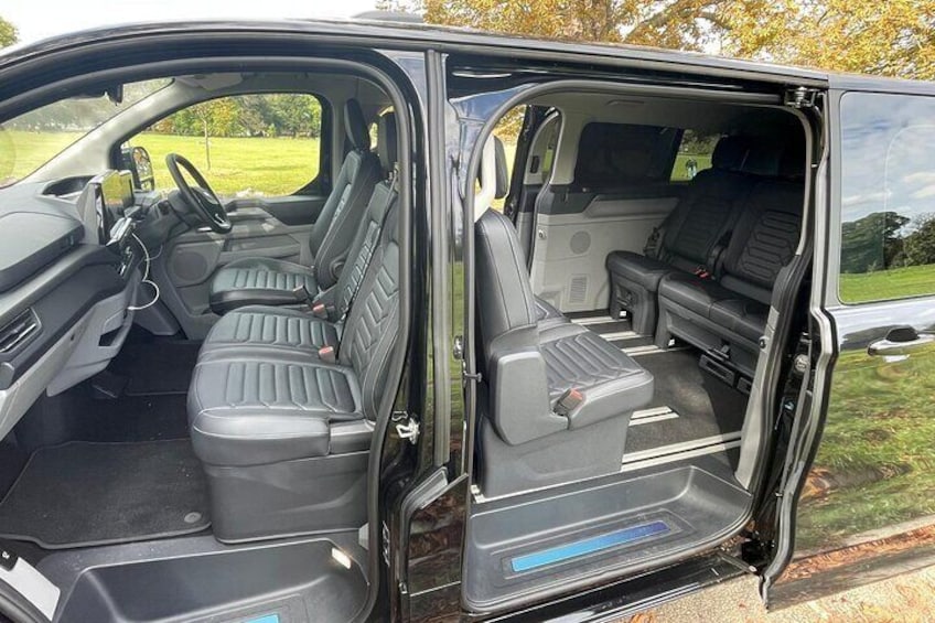 Interior de una camioneta con dos asientos, un volante y un tablero. 2