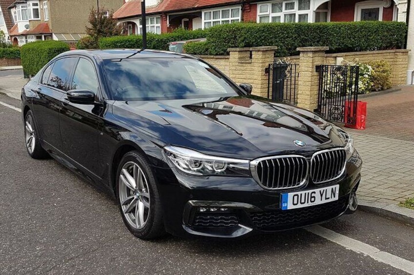 Un sedán BMW negro estacionado en una calle residencial. 5