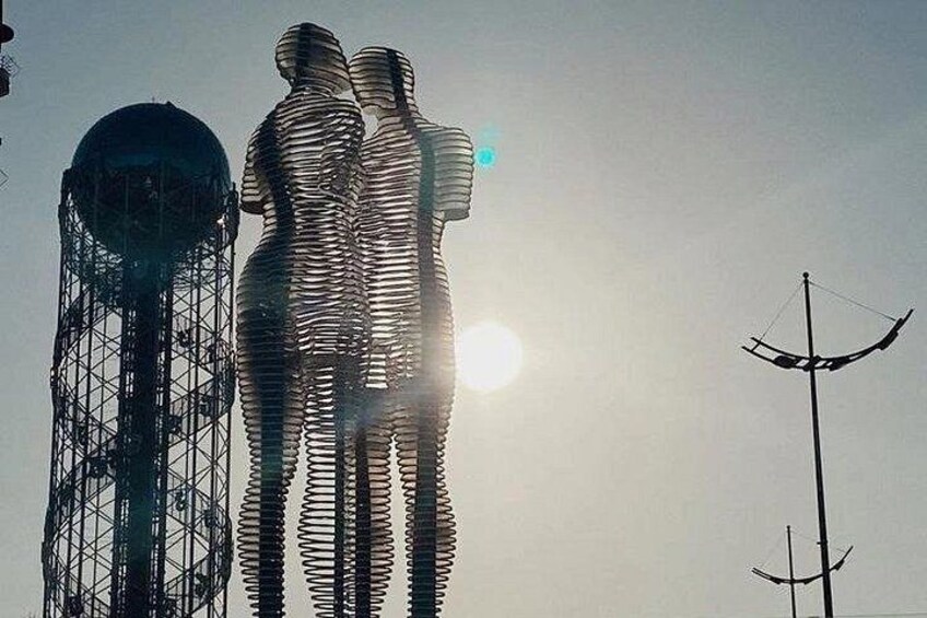 A large sculpture of two figures, a water tower, and a wind turbine. 4