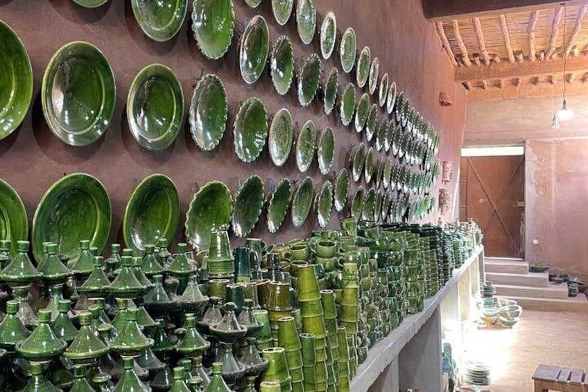 A display of green ceramic plates and vases in a store. 1