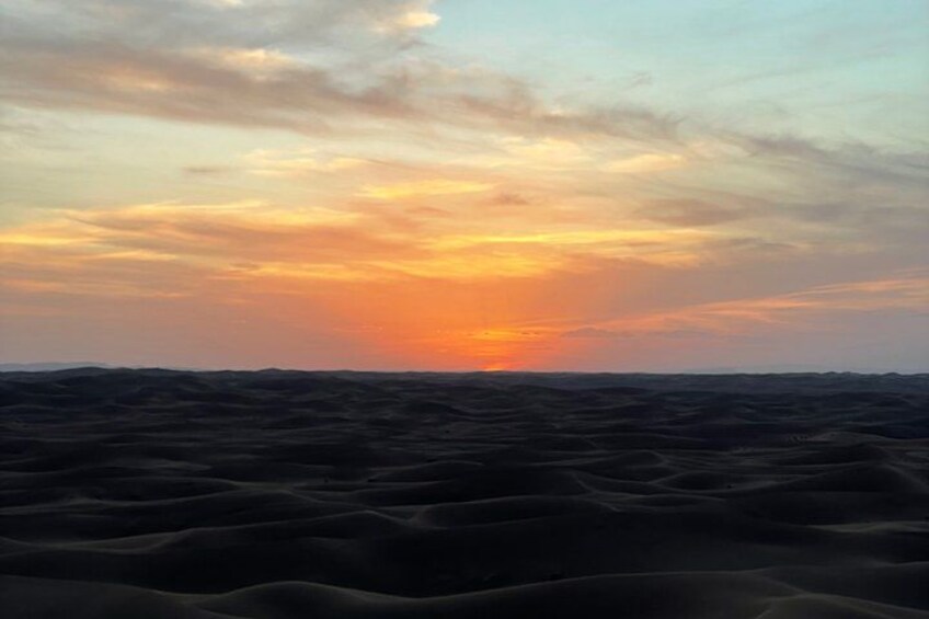 A desert landscape with sand dunes and a sunset. 5