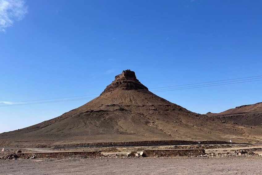 Una montaña grande y aislada con cima plana, rodeada por un paisaje árido. 3