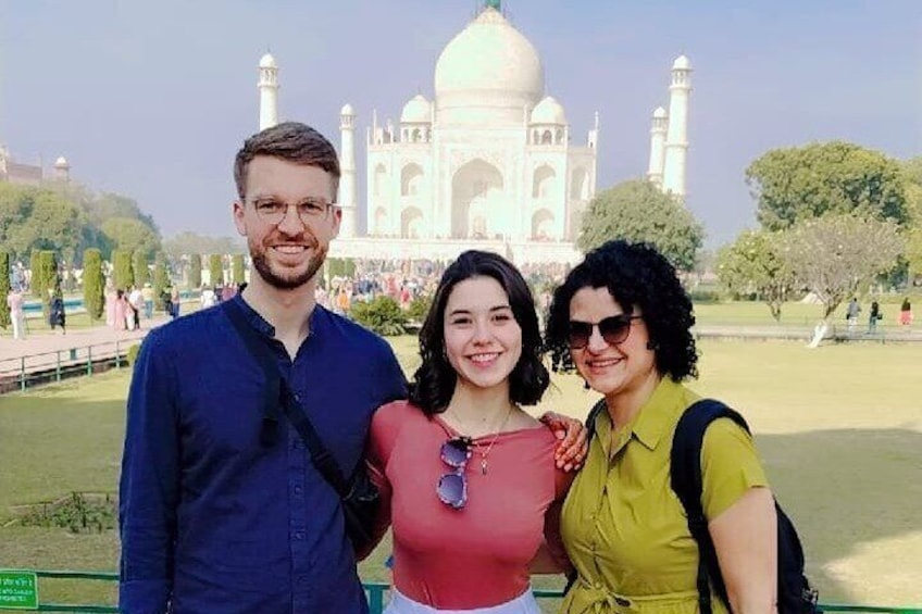Drie personen staan voor de Taj Mahal. 4