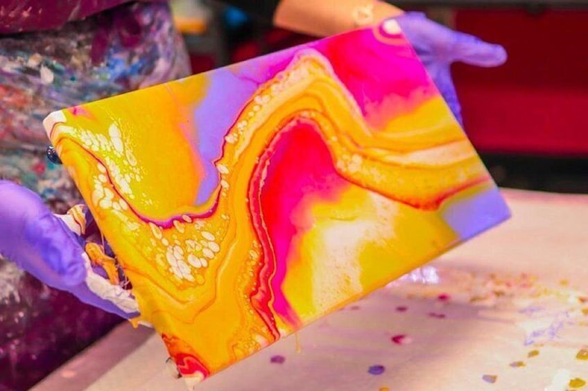 A person holding a colorful, marbled object. 3