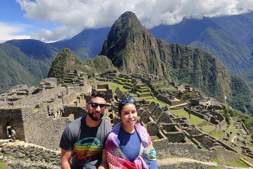 Una pareja en Machu Picchu con ruinas antiguas y montañas al fondo. 3