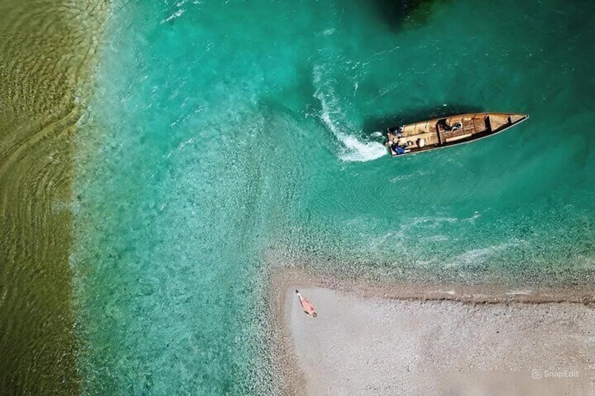 Vista aérea de un barco en aguas turquesas cerca de una playa de arena. 1