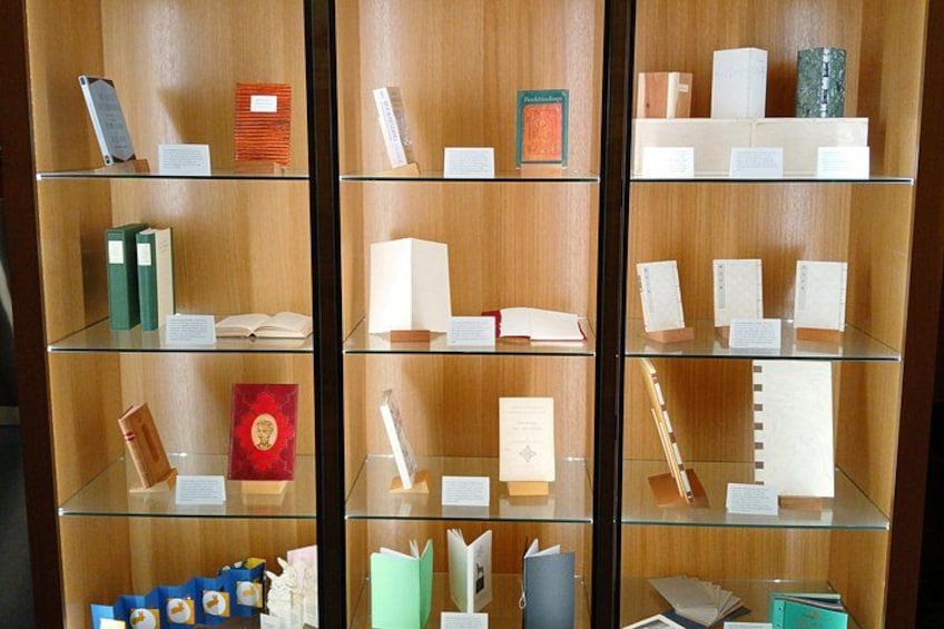 A library with glass display cases containing books and documents. 2
