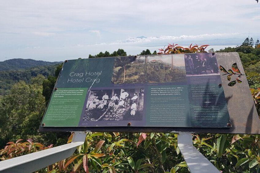A historical signboard with information about the Crag Hotel, set against a backdrop of lush greenery and mountains. 4