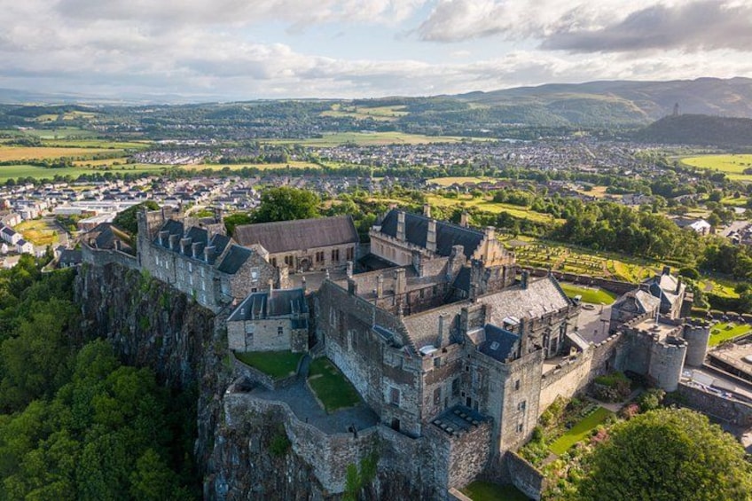Eine historische Burg auf einem Felsen mit Blick auf eine Stadt. 5