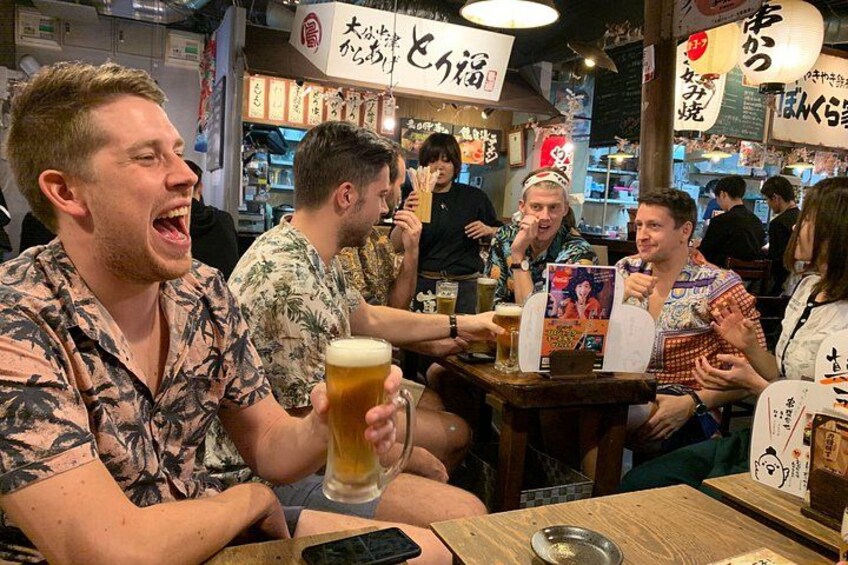 A group of people sitting at a table in a restaurant, holding beer glasses. 3