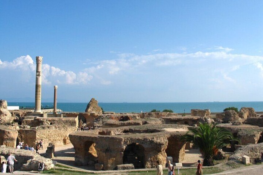 Ancient ruins with columns and arches near a coastline. 4