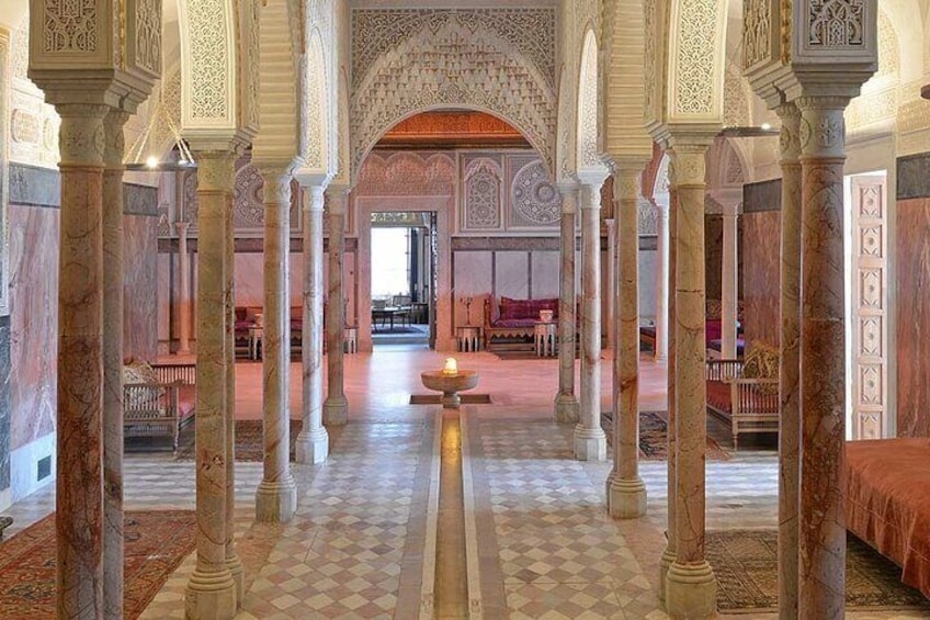 An ornate interior with high arches, detailed columns, and a checkered floor. 2