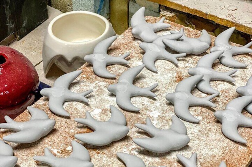 Keramische Vogelstatuen auf einer Werkbank. 5