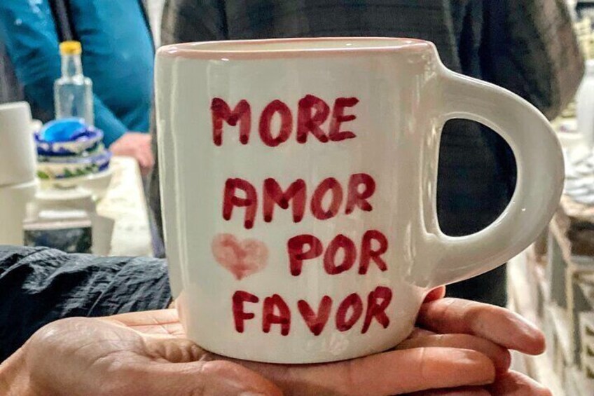 Eine weiße Tasse mit roter Schrift und Herzchen. 3