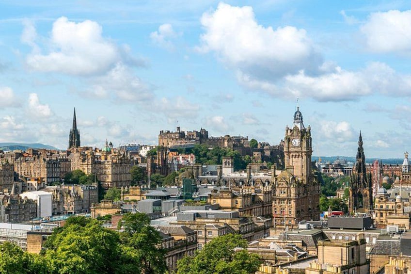 A historic cityscape with prominent architecture, including a clock tower and spires. 2
