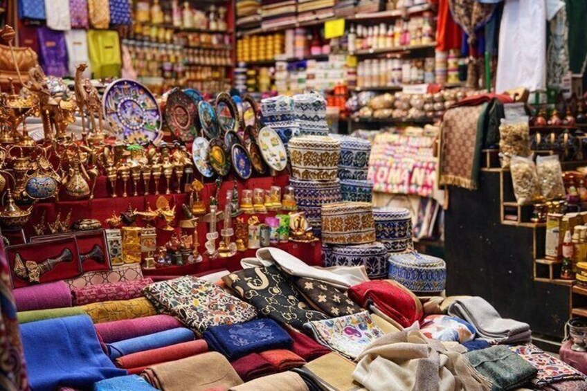 A market stall with textiles, pottery, and decorative items. 5