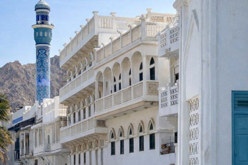 A white building with blue accents and a minaret. 2