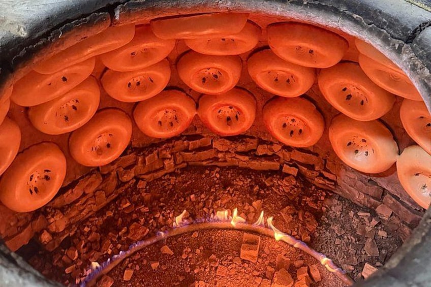 A circular structure with orange objects arranged in rows, a brick interior, and a glowing element at the bottom. 1