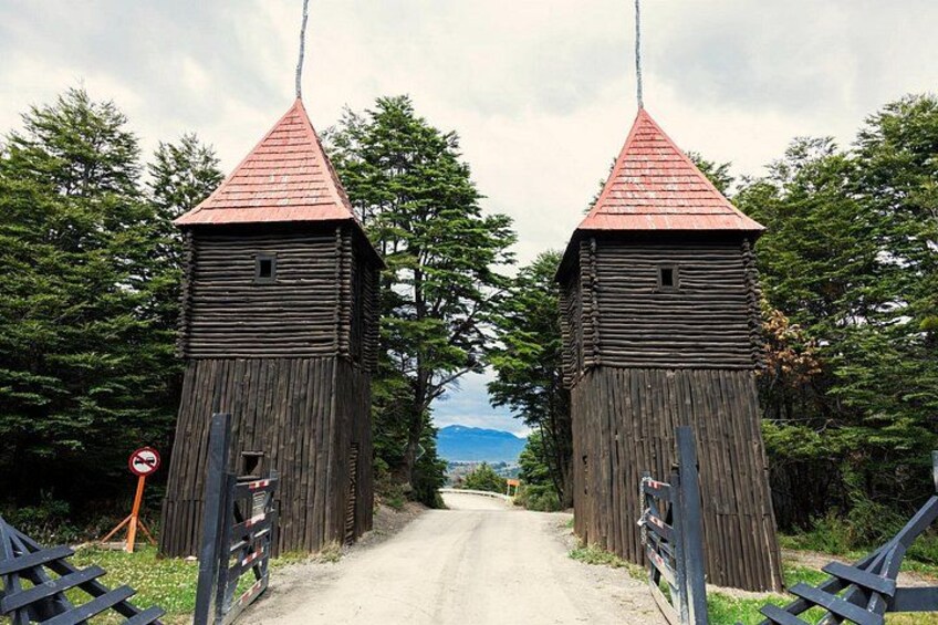 A wooden bridge with two towers, a no-entry sign, and a scenic view of mountains in the background. 4