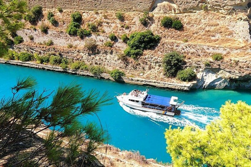 A boat on a turquoise body of water, surrounded by rocky terrain and sparse vegetation. 2