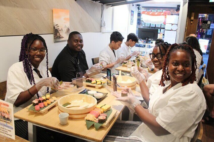 People preparing food, likely sushi, in a kitchen setting. 4