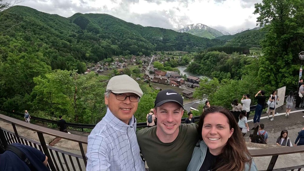 A scenic overlook with a valley below, featuring lush greenery and traditional buildings. 1