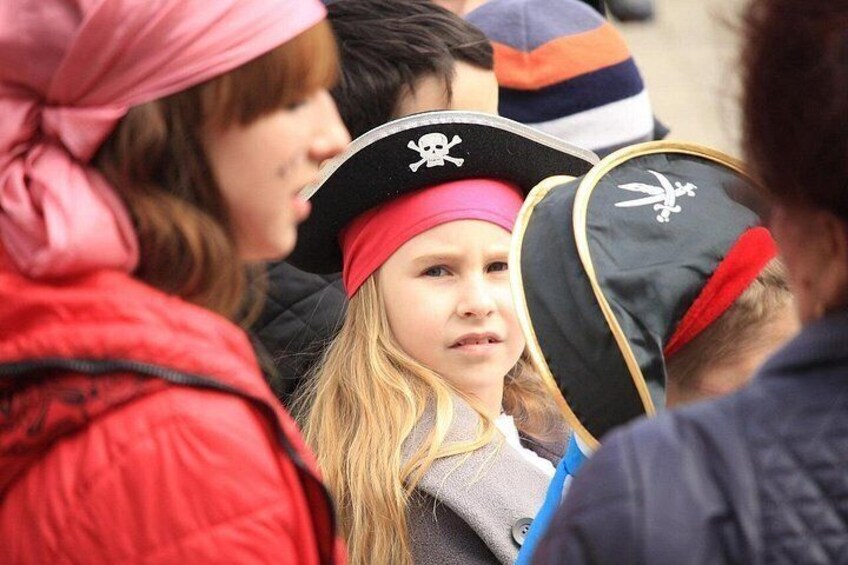 A crowd of people, some wearing pirate hats. 4