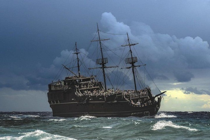 A large ship with multiple masts sailing on the ocean. 4